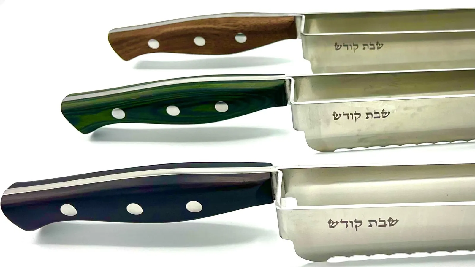 Close-up of the black, green and brown handles with שבת קודש engraved on the blades
